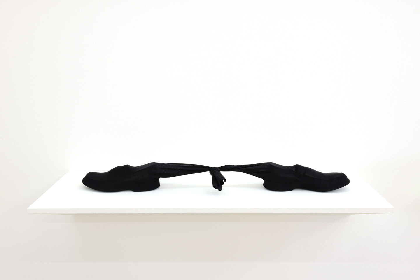 Left Apart, 1999, Two leather shoes in sizes 41 and 43, socks, 99 x 10 x 11 cm